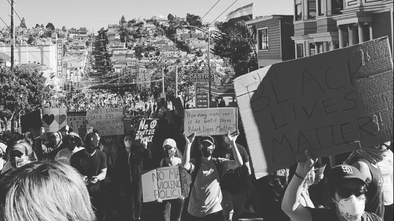 Protestors carry signs featuring statements like black lives matter, no justice no peace, and more
